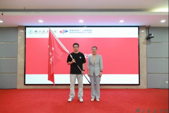 谭艳为志愿服务队授旗